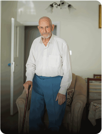 Oude man met baard en wandelstok in huis